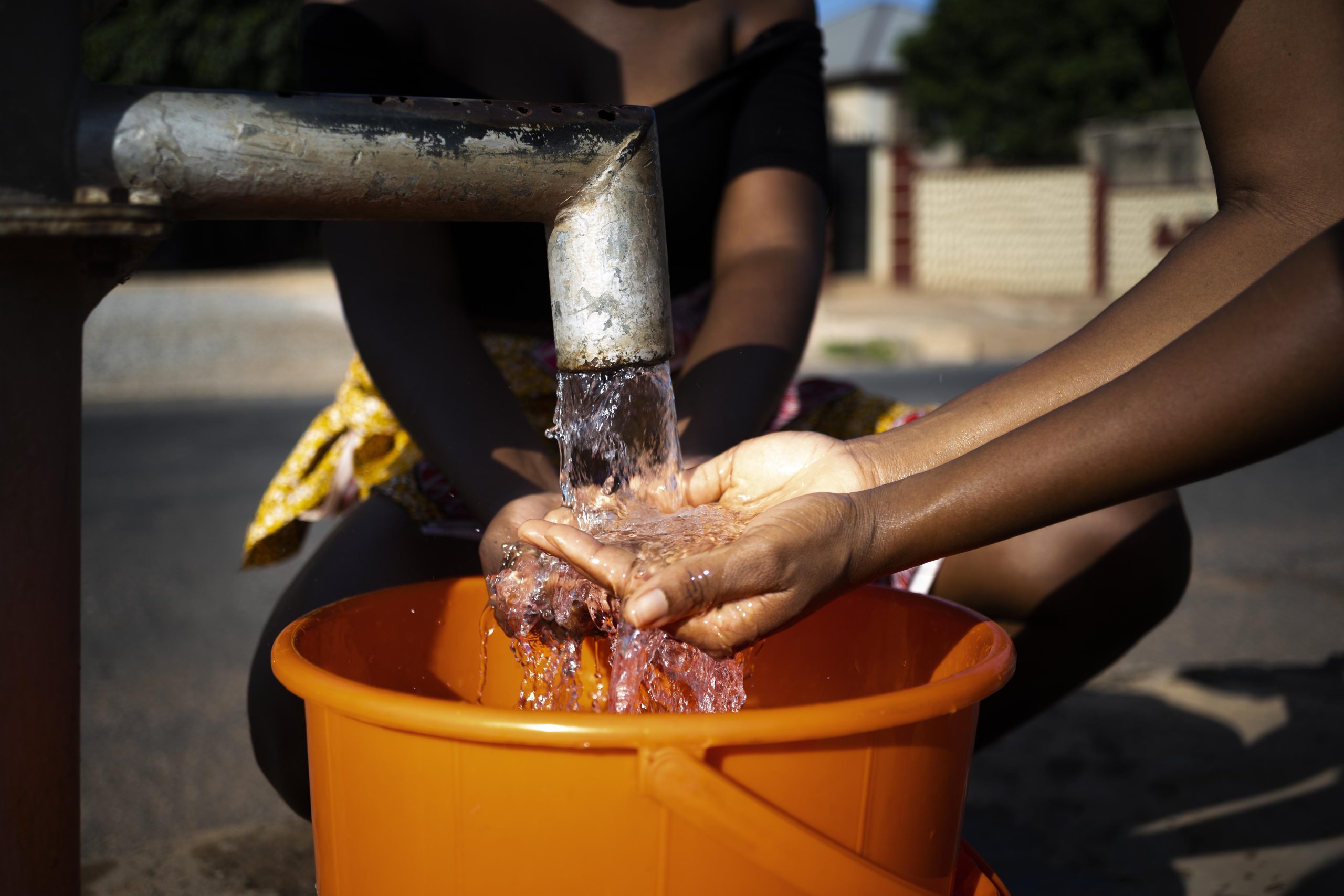 Home 3 Child from africa drinking water from water well pump