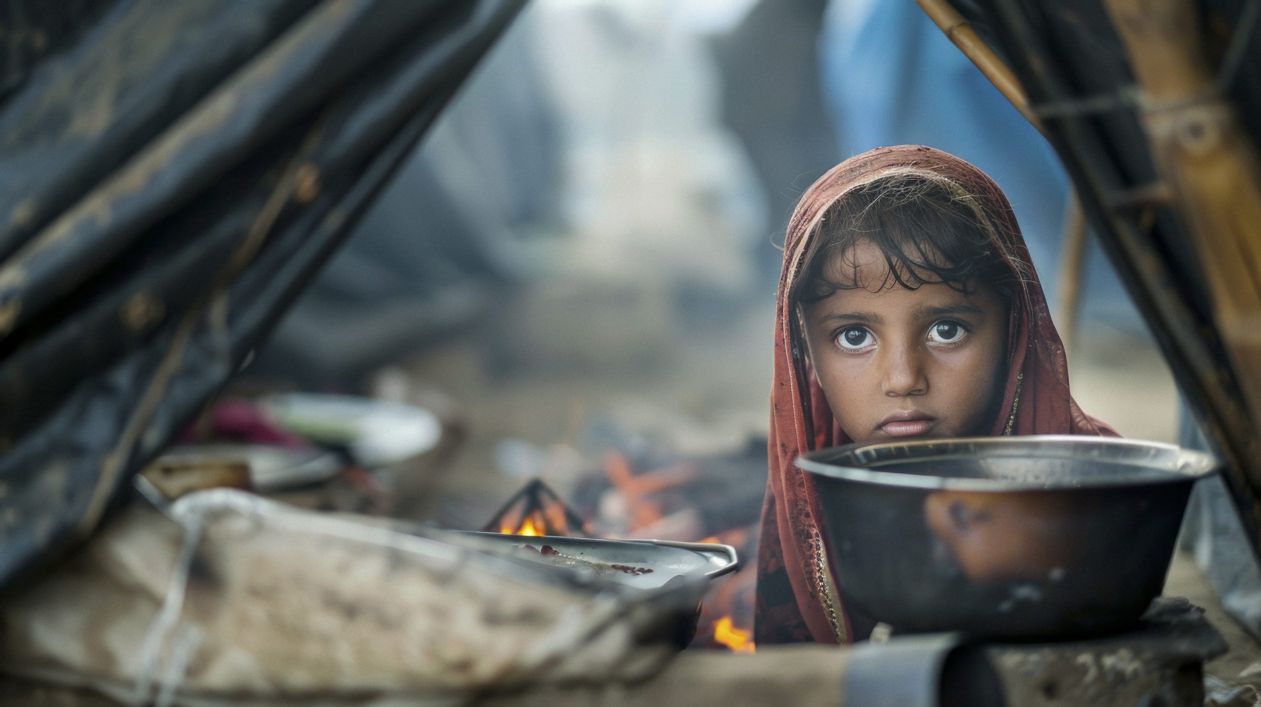 Child looking at the camera inside refugee camp tents